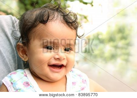 Little indian girl laughing and resting on her father's shoulder