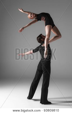 two young modern ballet dancers on gray studio background
