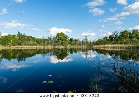 White Clouds On The Blue Sky Over Blue Lake
