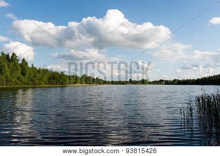 White Clouds On The Blue Sky Over Blue Lake