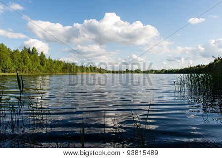 White Clouds On The Blue Sky Over Blue Lake