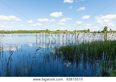 White Clouds On The Blue Sky Over Blue Lake
