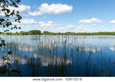 White Clouds On The Blue Sky Over Blue Lake