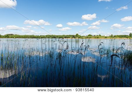 White Clouds On The Blue Sky Over Blue Lake