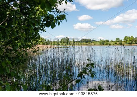 White Clouds On The Blue Sky Over Blue Lake