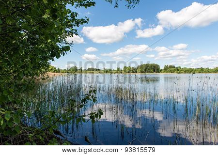White Clouds On The Blue Sky Over Blue Lake