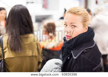 Female shopper queuing in line at cashier.