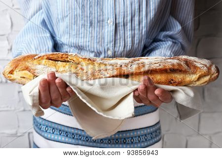 Woman holding tasty fresh bread, close up