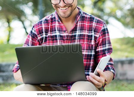 Young Man Smartphone Browsing Laptop Concept