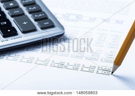 Caclulator and Pencil on the Document - Close Up