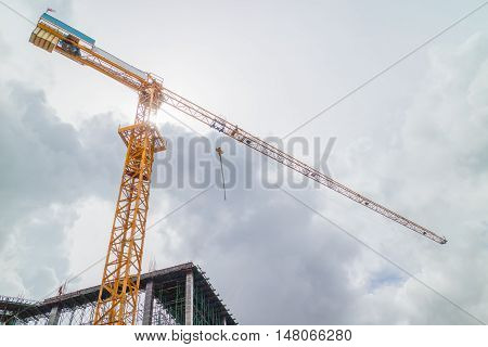 Tower crane on a construction site against dark sky.