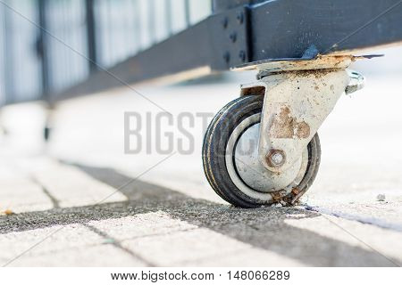 The castor rubber wheel under steel gate on concrete floor .