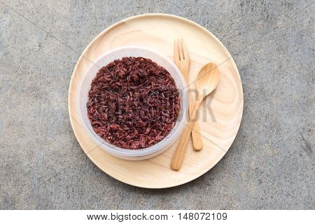 Cooked rice berry (purple rice) on wooden plate