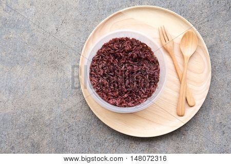 Cooked rice berry (purple rice) on wooden plate eat clean concept.