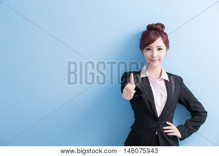 business woman is smile to you and thumbs up isolated on blue background asian