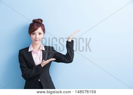 business woman is smile and show something to you with isolated on blue background asian
