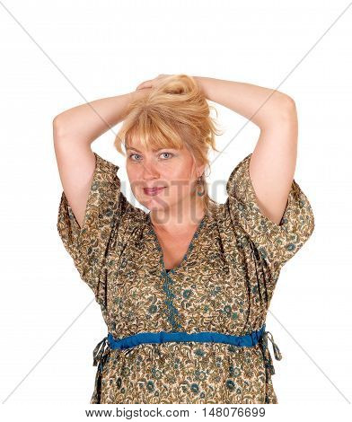 A portrait image of a pretty blond woman in a dress with her hands on her head isolated for white background.