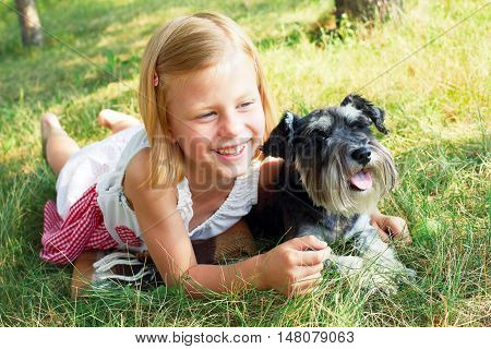 Happy cute little girl hugging her little dog