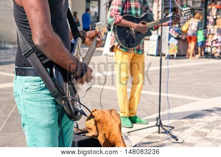 Black music street african performers playing electric guitar and bass at city square - Afro american colorful reggae musician artist with electric instruments close up scene - Bright day lights