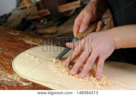Luthier makes installation rosette classical guitar with the help of circular knives and gouges