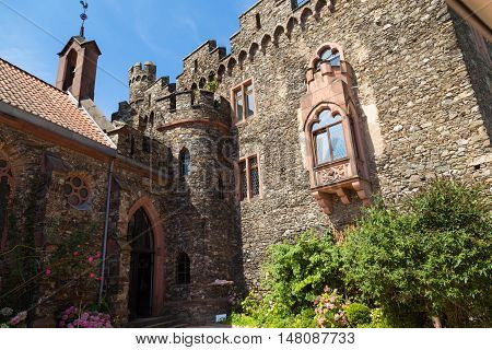 Reichenstein Castle Rhine Valley Germany - UNESCO World Heritage - courtyard : stone wall with windows tower balcony against blue sky
