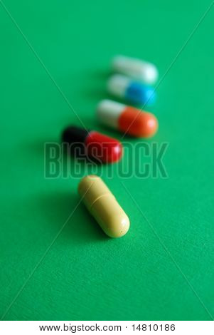 pills on green background in row