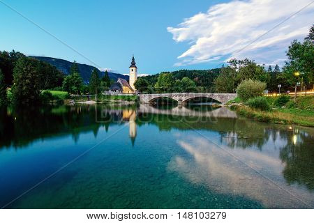BOHINJ LAKE SLOVENIA - AUGUST 22 2016: Church of St. John the Baptist at Bohinj Lake is over 700 years old and is a beautiful example of Middle Age architecture and fresco painting in Slovenia.