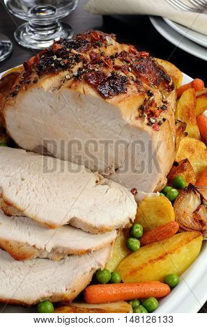 A plate of roasted turkey breast slices with vegetables closeup