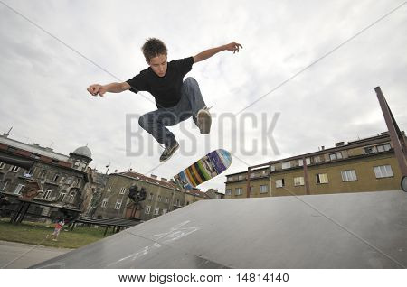 Menino praticando skate em um parque de skate