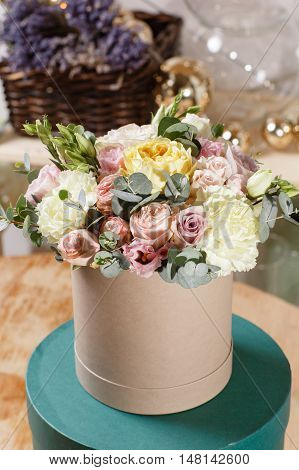 Rich bunch of composition in hatbox. A fresh bouquet of flowers of different colors mix.