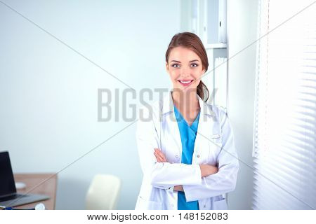 Portrait of young woman doctor with white coat standing in hospital