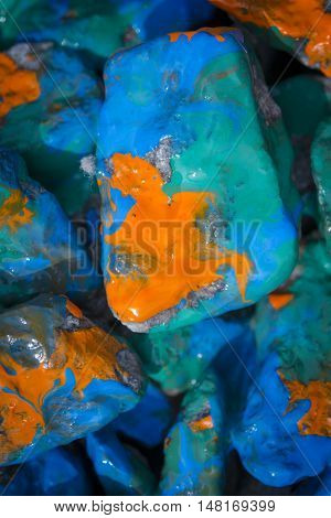 paint painted stones closeup. Painted in orange, blue, green color