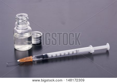 One Syringe And A Mysterious Vial On A Dirty Table.