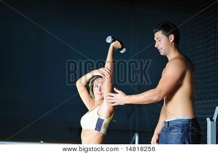 femme dans la gim de remise en forme avec coach personal trainer