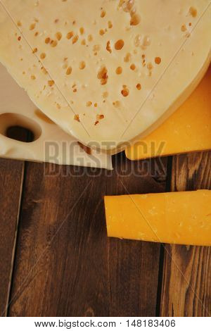various types of fresh raw aged delicatessen cheese on wooden table cheddar edam swiss