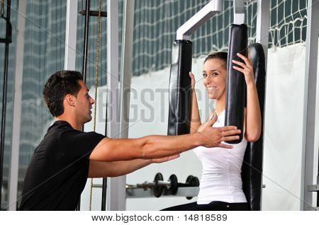 femme dans la gim de remise en forme avec coach personal trainer
