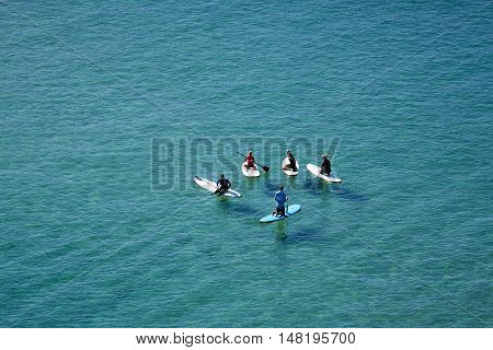 Five board riders having a conversation whilst sitting in deep water