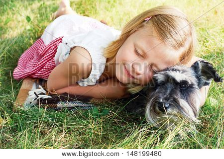 Happy cute little girl hugging her little dog