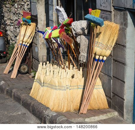 Street Retail Outlet selling traditional Household cleaning Items large Heap of Brooms and Besoms Mops Swobs variety of Brushes for cleaning Istanbul City Turkey