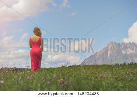 female in a red dress in field at sunset