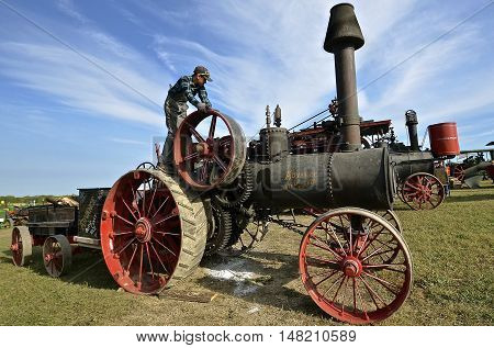 ROLLAG, MINNESOTA, Sept 1. 2016: An unidentified young lad works on an Advance Straw Burner vintage steam engine at the West Central Steam Threshers Reunion in Rollag, MN attended by 1000's held annually on Labor Day weekend.