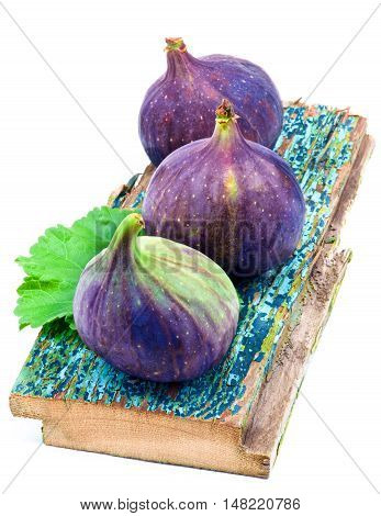 Three Perfect Ripe Fig on Cracked Wooden Planch isolated on White background