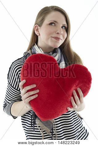 Woman cuddling with a red heart pillow