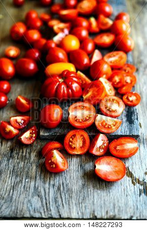 Tomato on wooden table. Freshly Picked red Tomatoes. Variation of tomatoes on wooden surface. Vegetables in the section. Harvesting. Healthy food from the garden.