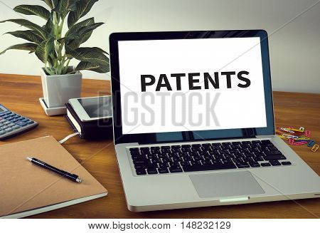 PATENTS Laptop on table. Warm tone businessman working
