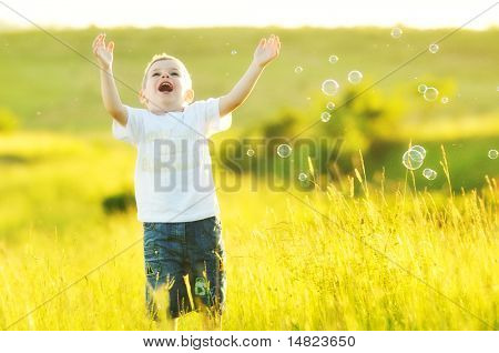 heureux jeune bel enfant Amusez-vous sur pouve avec jouet de bulles de savon