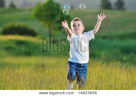heureux jeune bel enfant Amusez-vous sur pouve avec jouet de bulles de savon