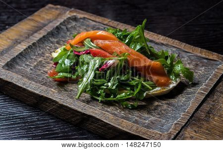 sandwich with salmon and fresh herbs on the board