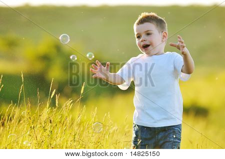 heureux jeune bel enfant Amusez-vous sur pouve avec jouet de bulles de savon