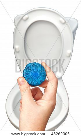 Hands holding blue toilet cleaner tablets for flush mechanism inside cistern of toilet.